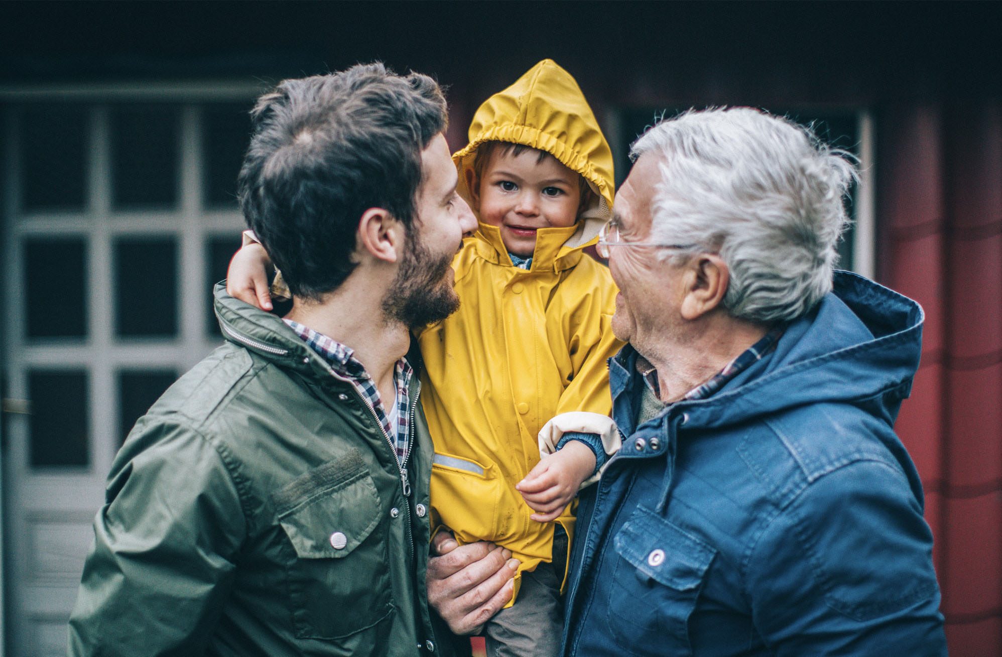 three generations grandfather father and son standing outside