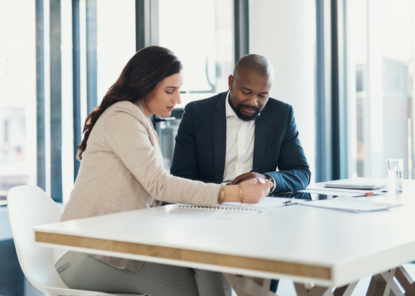 Image of man and woman at desk looking at financial plans.
